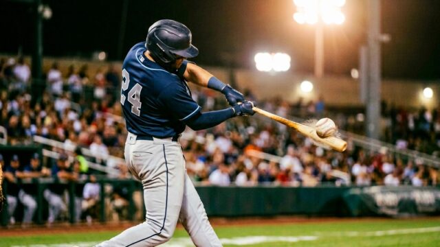 Baseball batter making powerful contact with ball launching off bat