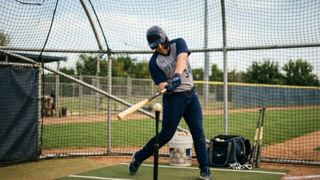 Baseball player in focused practice session at batting cage